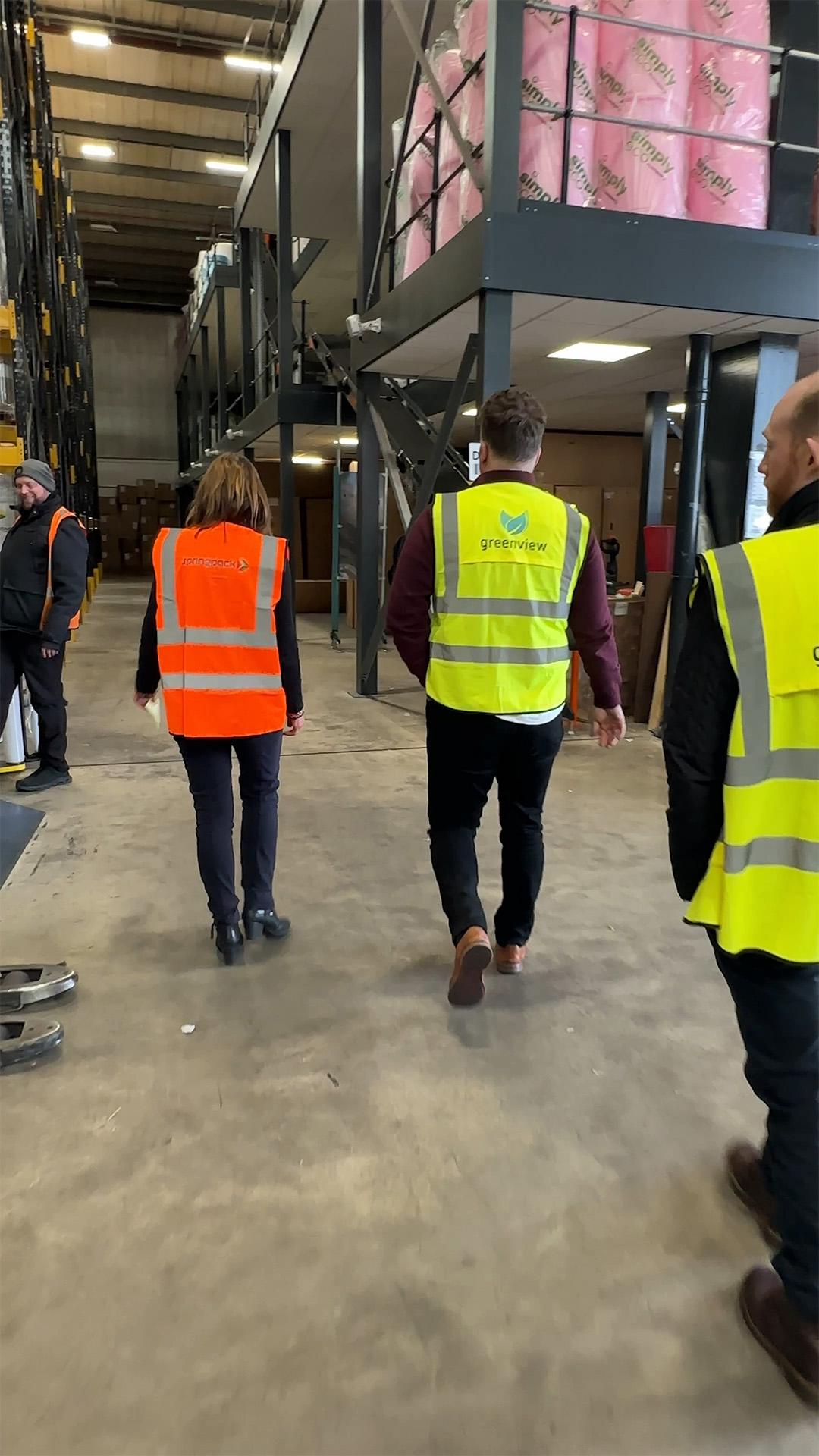 Greenview team members in hi-vis vests walking through the recycling warehouse